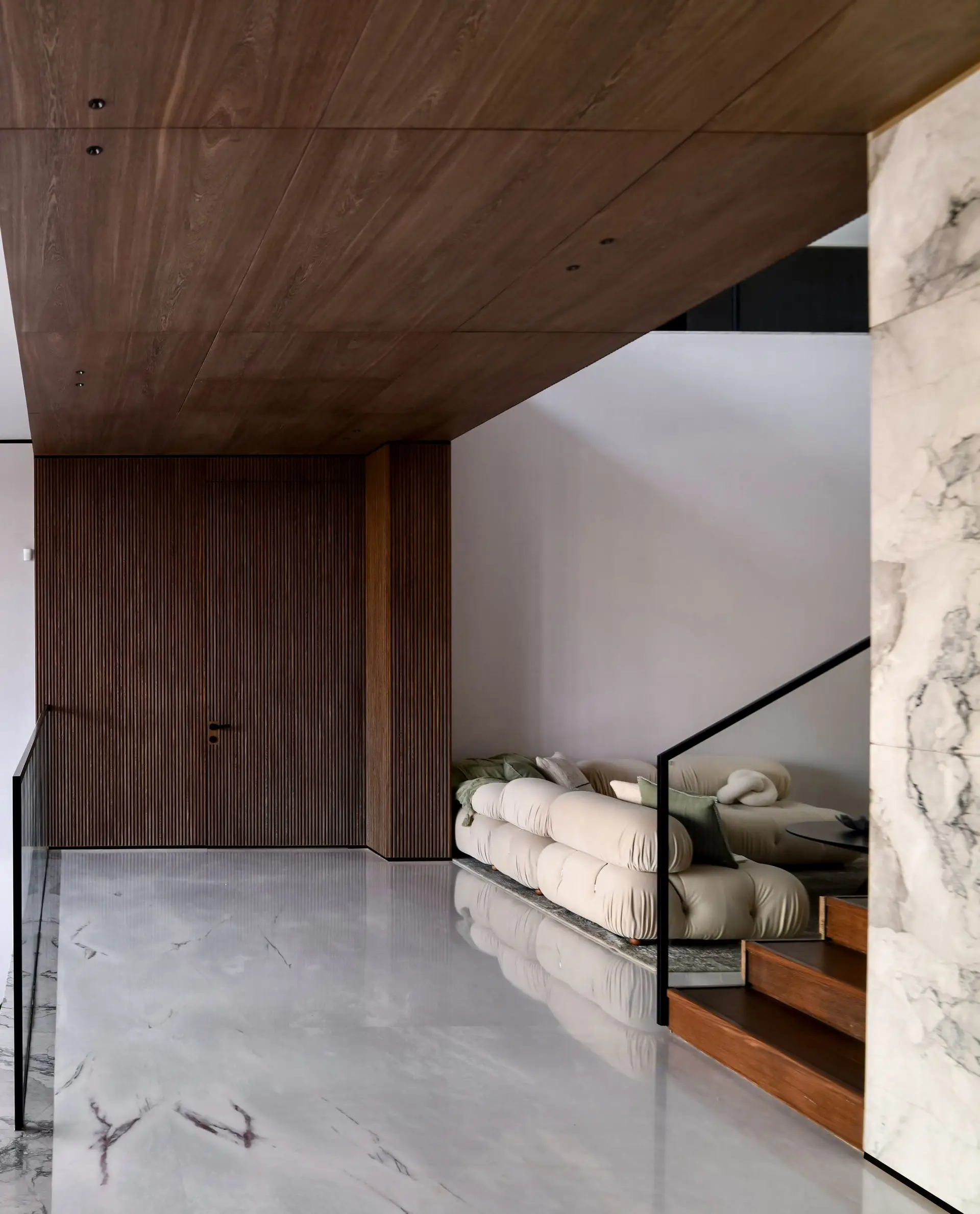Bespoke British interior featuring fluted oak cabinetry, honed marble, and ambient architectural lighting