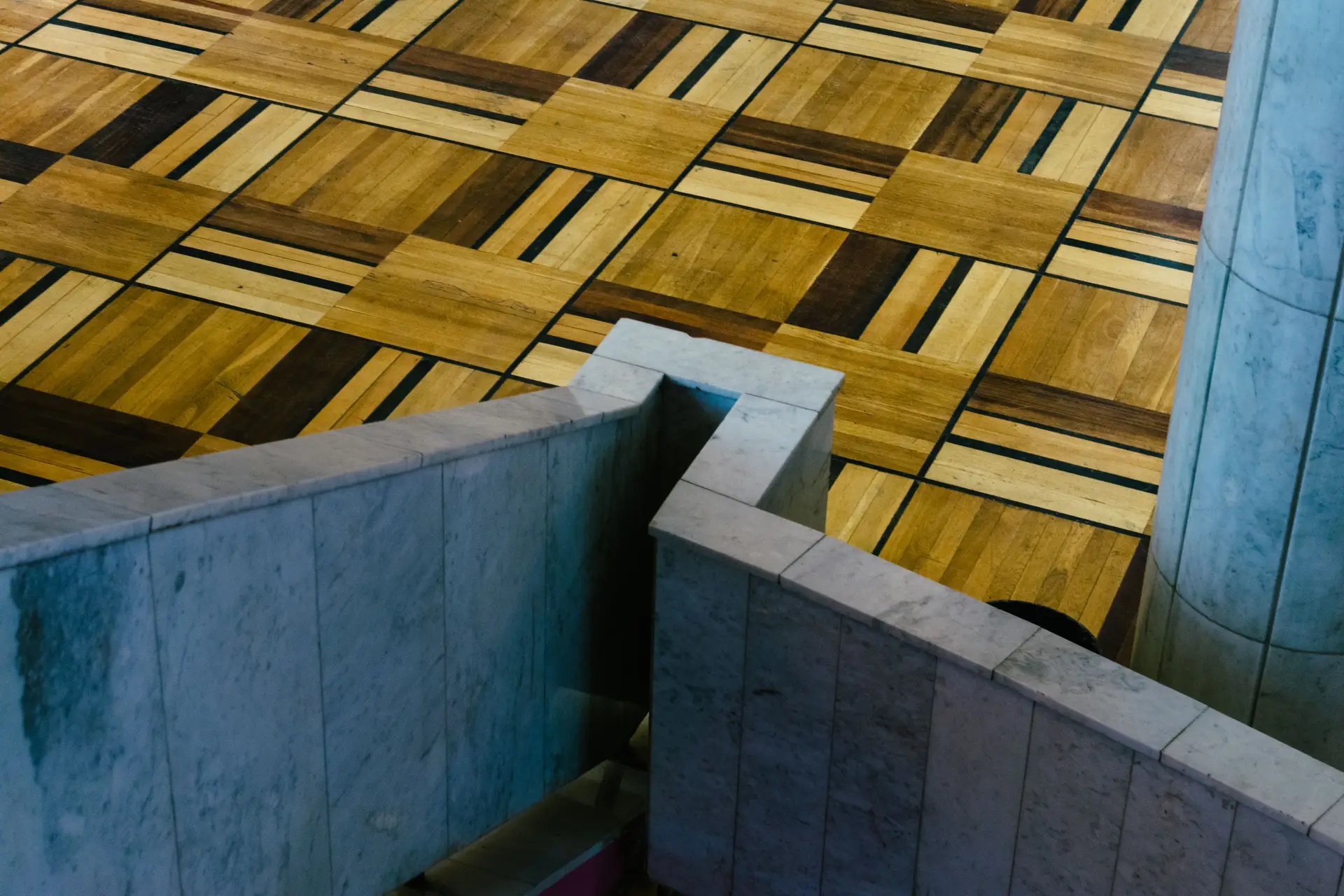 Natural marble junction meeting decorative patterned parquet timber